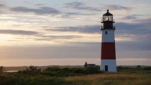 a red and white striped lighthouse and the sunsetting