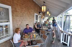 A restaurant covered porch with people dining.
