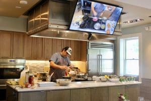 a man with a hat in a kitchen cooking.