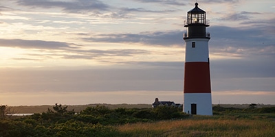 red and white lighthouse with the sunsetting